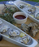 Fresh oysters on the half shell at Oysterville Sea Farms, served with our signature finish sauce for the perfect bite!